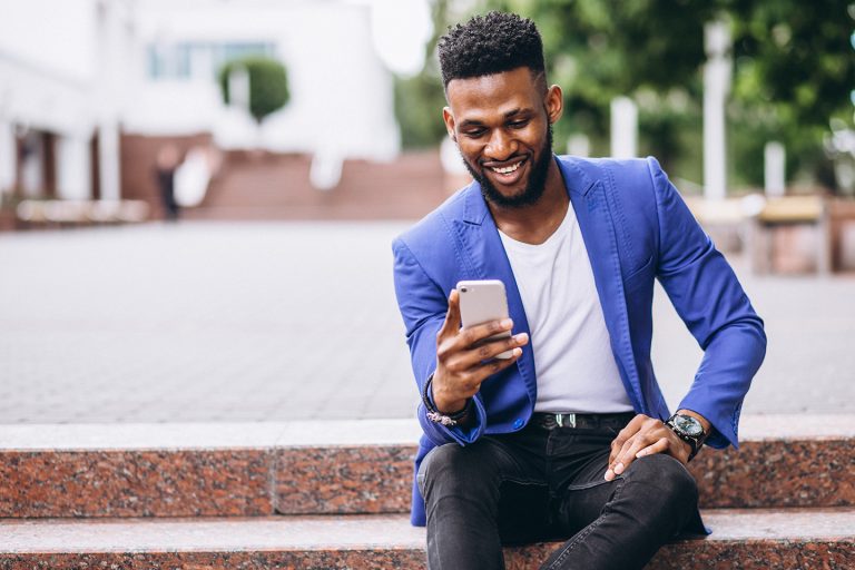 African american man in blue jacket using phone